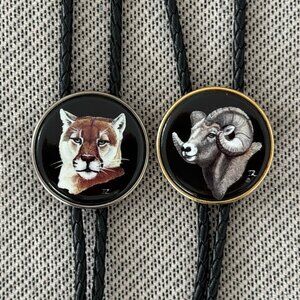 2 bolo ties by Julie Zsupnik, mountain lion and ram / Aries